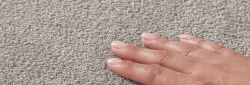 grey polypropylene twist carpets being stroked by a manicured white female hand